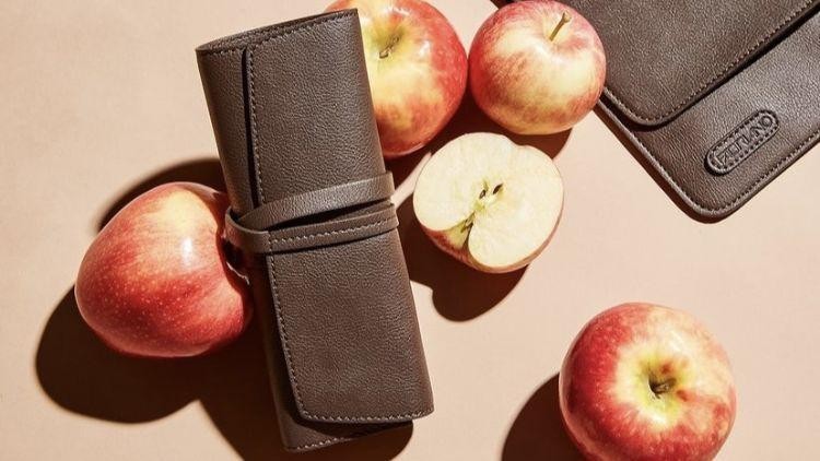 Apple-waste based leather case and pouch surrounded by apples